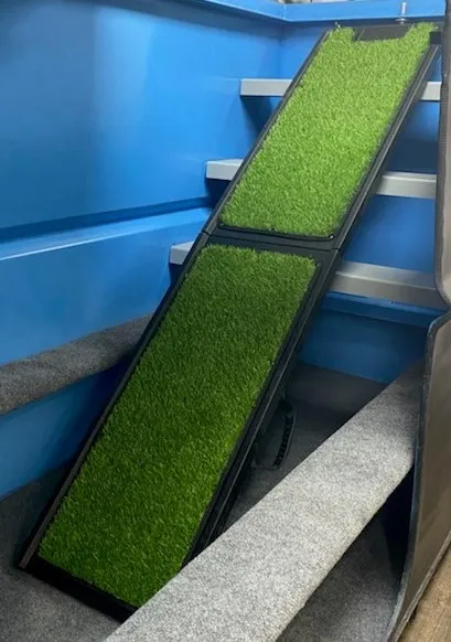 Artificial turf dog ramp installed inside a galvanized underground storm shelter for safe and easy pet access during emergencies.